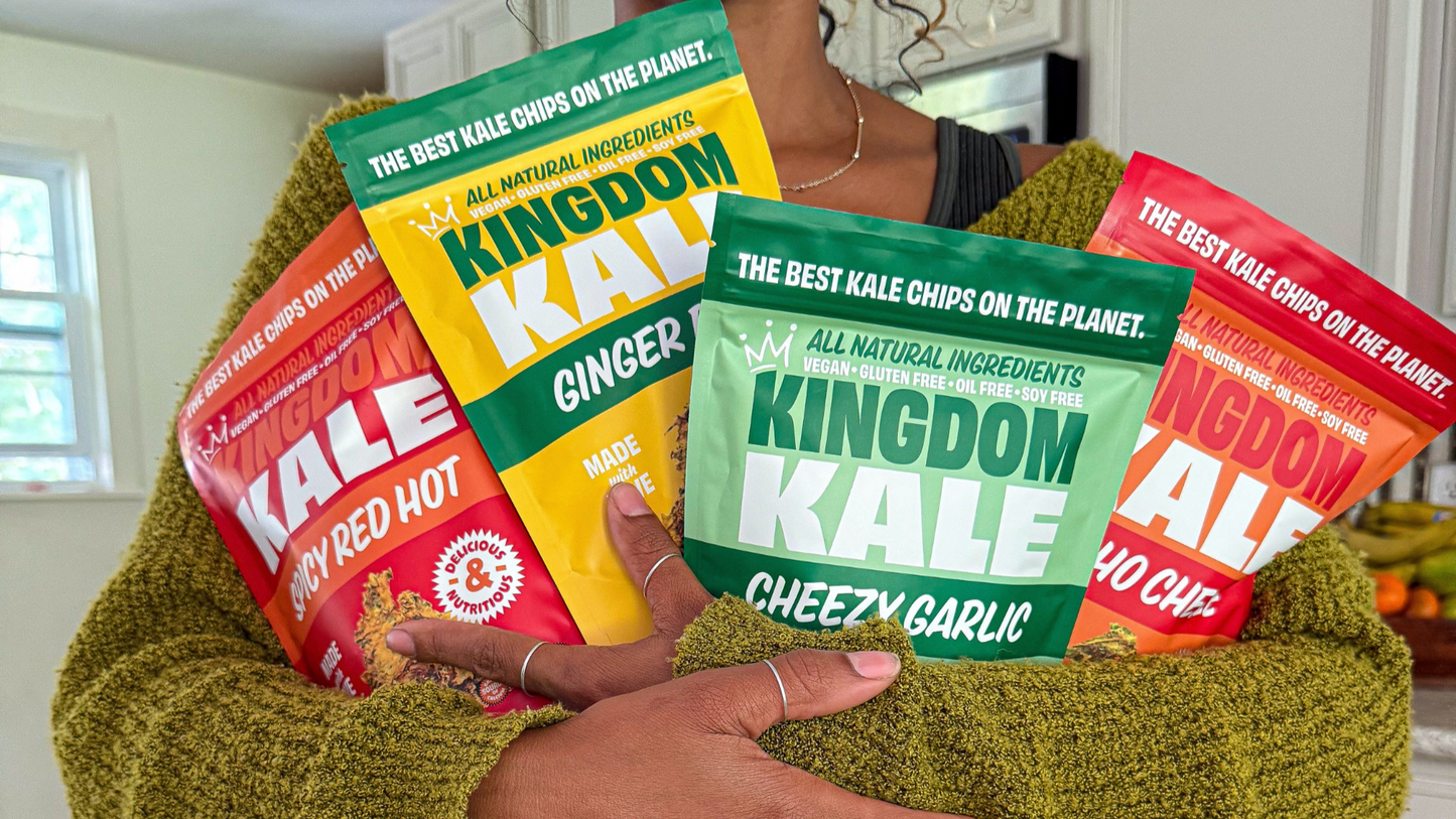 Person holding Kingdom Kale chips in a kitchen setting